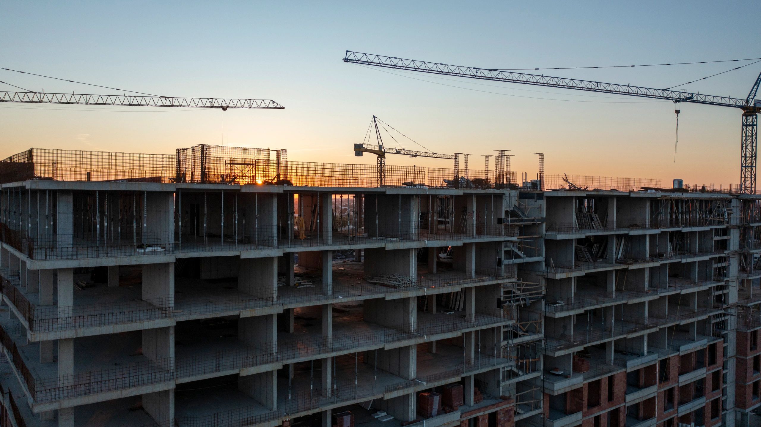 Large construction site at sunset representing construction delivery